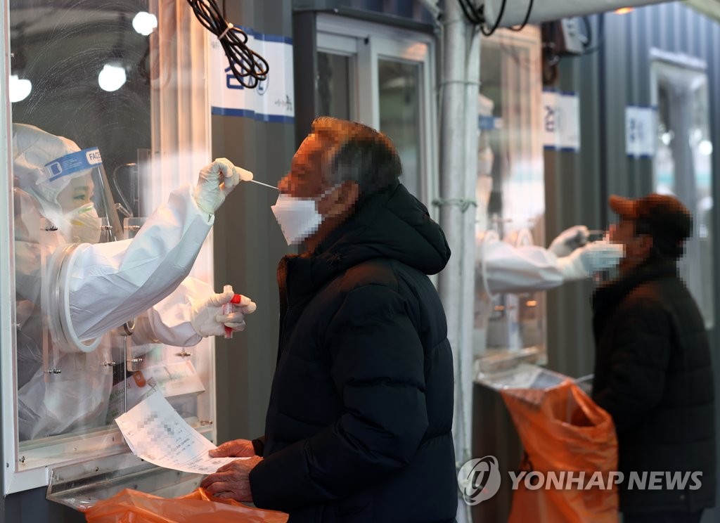 This photo, taken on Feb. 12, 2021, shows people getting a COVID-19 tests at a testing site at Seoul Station in central Seoul. (Yonhap)