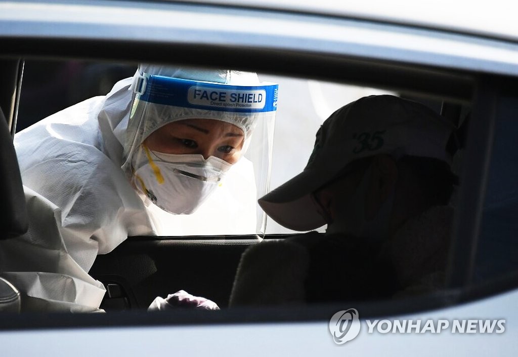 A health care worker conducts a COVID-19 test at a temporary testing station in Pyeongchang, 182 kilometers east of Seoul, on March 11, 2021, in this photo provided by Pyeongchang County. (PHOTO NOT FOR SALE) (Yonhap)