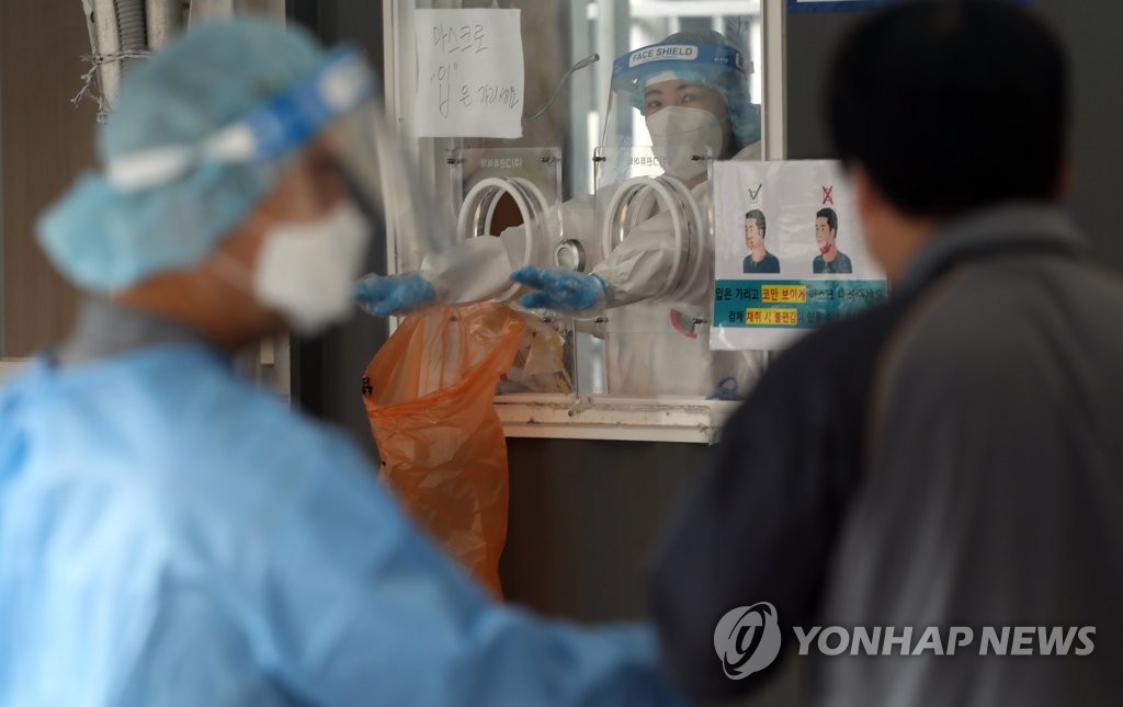 Medical workers carry out tests at a coronavirus testing center in Seoul on May 18, 2021. (Yonhap)