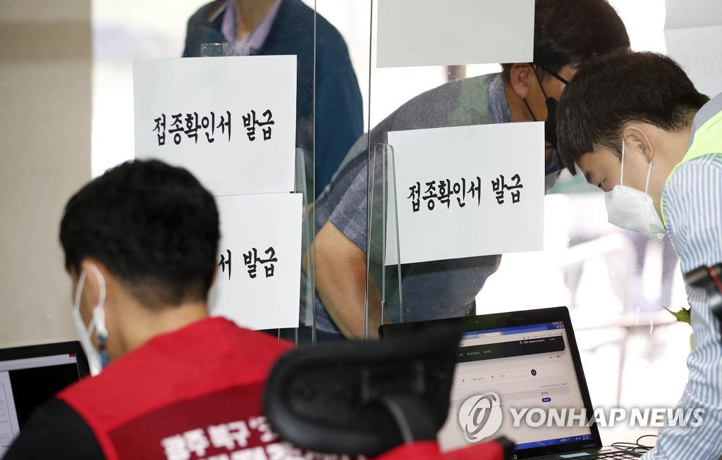 Des employés dans un centre de vaccination contre le nouveau coronavirus (Covid-19) à Gwangju, à 330 km au sud de Séoul, émettent des certificats pour ceux qui ont achevé leur inoculation, le mercredi 2 juin 2021. (Photo fournie par le bureau de l'arrondissement de Buk à Gwangju. Revente et archivage interdits) 