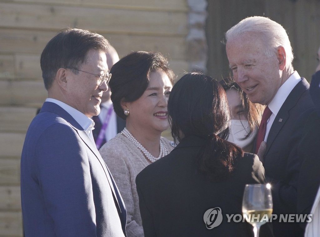 Le président Moon Jae-in (à gauche), son épouse Kim Jung-sook (au centre) et le président américain Joe Biden conversent le samedi 12 juin 2021 lors d'un dîner officiel du G7 à l'hôtel Carbis Bay, en Cornouailles, au Royaume-Uni.