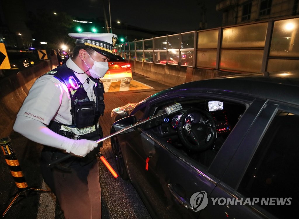 This July 15, 2021, file photo shows a police officer conducting a breathalyzer test on a driver in Seoul. (Yonhap)