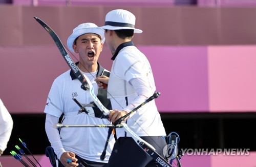 South Korean archer Kim Je-deok (L) celebrates with his teammate An San during the final of the mixed team event at the Tokyo Olympics at Yumenoshima Park Archery Field in Tokyo on July 24, 2021. (Yonhap)