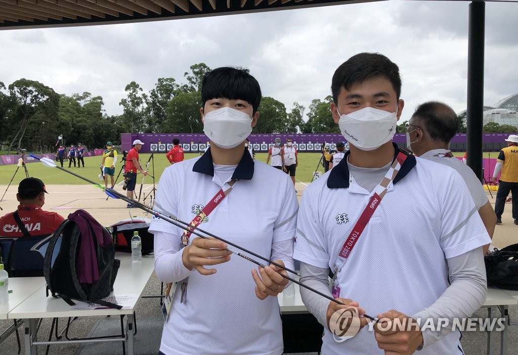 South Korean archers An San (L) and Kim Je-deok pose with their "Robin Hood" arrows from the Tokyo Olympic mixed team archery competition at Yumenoshima Park Archery Field in Tokyo on July 31, 2021, before donating them to the International Olympic Committee's Olympic Museum in Switzerland, in the photo provided by the Korea Archery Association on Aug. 1. (PHOTO NOT FOR SALE) (Yonhap)