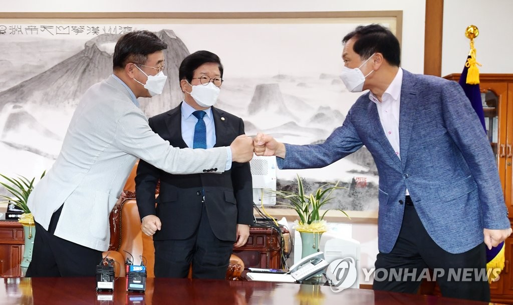 The floor leaders of the Democratic Party and the People Power Party greet each other during their meeting on Aug. 29, 2021 at the National Assembly in Seoul. (Yonhap)