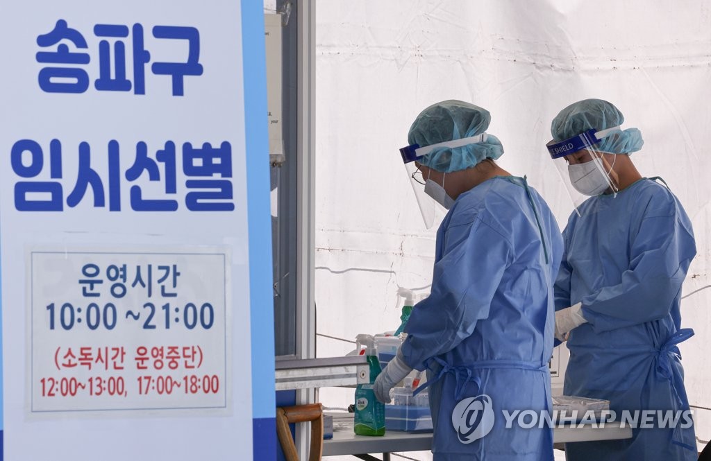 Health workers in protective gear prepare to work at a makeshift COVID-19 testing clinic in Seoul on Sept. 16, 2021. (Yonhap)