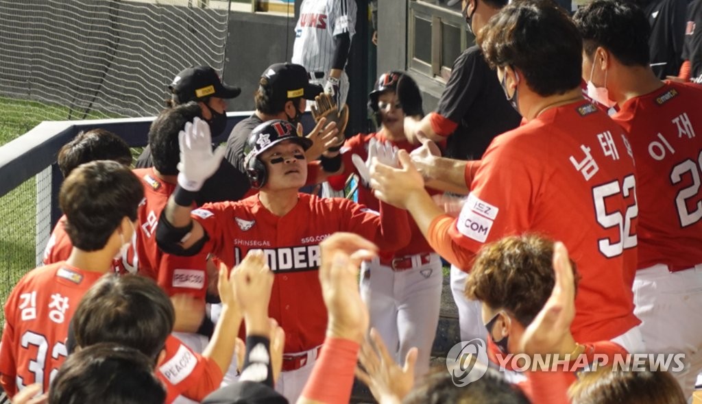 In this photo provided by the SSG Landers, outfielder Choo Shin-soo (C) is congratulated by his teammates after hitting his 20th home run of the Korea Baseball Organization (KBO) season against the LG Twins at Jamsil Baseball Stadium in Seoul, and becoming the oldest member of the 20-20 club in KBO history at 39 years, two months and 22 days old. (PHOTO NOT FOR SALE) (Yonhap)