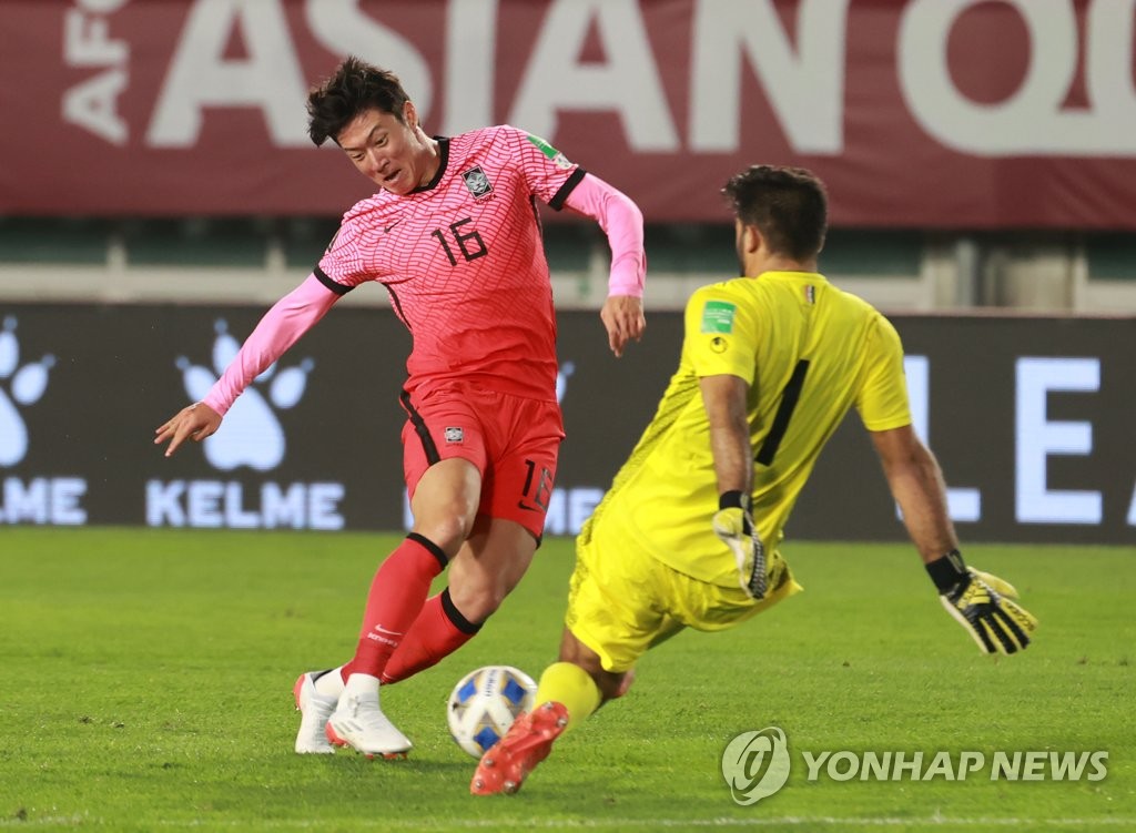 Hwang Ui-jo of South Korea (L) tries to get past Syrian goalkeeper Ibrahim Alma during the teams' Group A match in the final Asian qualifying round for the 2022 FIFA World Cup at Ansan Wa Stadium in Ansan, Gyeonggi Province, on Oct. 7, 2021. (Yonhap)