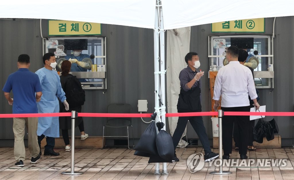 Citizens receive COVID-19 tests at a makeshift clinic in central Seoul on Oct. 9, 2021. (Yonhap)