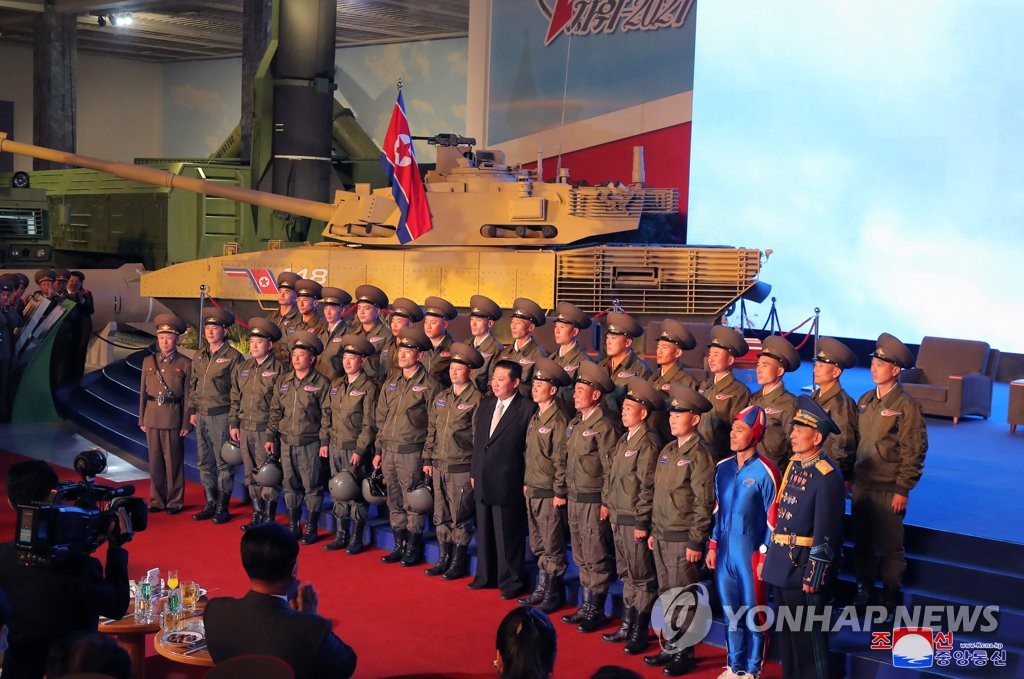 North Korean leader Kim Jong-un (7th from R, front row) poses during a visit to a defense development exhibition, Self-Defence-2021, in Pyongyang on Oct. 11, 2021, in this photo released by the Korean Central News Agency. (For Use Only in the Republic of Korea. No Redistribution) (Yonhap)