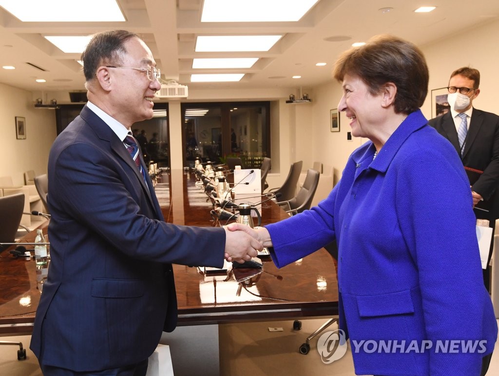 This photo, provided by the Ministry of Economy and Finance on Oct. 13, 2021, shows South Korean Finance Minister Hong Nam-ki (L) shaking hands with Kristalina Georgieva, managing director of the International Monetary Fund, ahead of their meeting in Washington, D.C. on Tuesday (local time). (PHOTO NOT FOR SALE) (Yonhap)