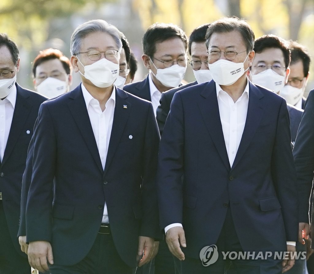 President Moon Jae-in (R) and Gyeonggi Province Gov. Lee Jae-myung, the ruling Democratic Party's presidential nominee, walk together after a government meeting on balanced regional development in the central city of Sejong on Oct. 14, 2021. (Yonhap)