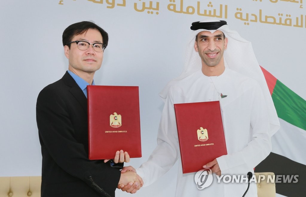 South Korean Trade Minister Yeo Han-koo (L) and United Arab Emirates Minister of State for Foreign Trade Thani Ahmed Al Zeyoudi shake hands after signing an agreement to push for a Comprehensive Economic Partnership Agreement in Dubai on Oct. 14, 2021, in this photo released by the Ministry of Trade, Industry and Energy. (PHOTO NOT FOR SALE) (Yonhap)