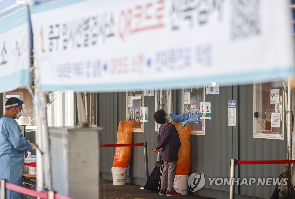 This file photo shows a medical worker taking a sample while carrying out a COVID-19 test at a testing station in Seoul on Oct. 22, 2021. (Yonhap)