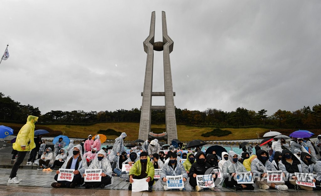 Protesters stage a sit-in at the May 18th National Cemetery in the southwestern city of Gwangju on Nov. 10, 2021, to block a visit by Yoon Seok-youl, the presidential nominee of the conservative opposition People Power Party (PPP), to the cemetery for the victims of the 1980 Gwangju pro-democracy uprising. (Pool photo) (Yonhap)