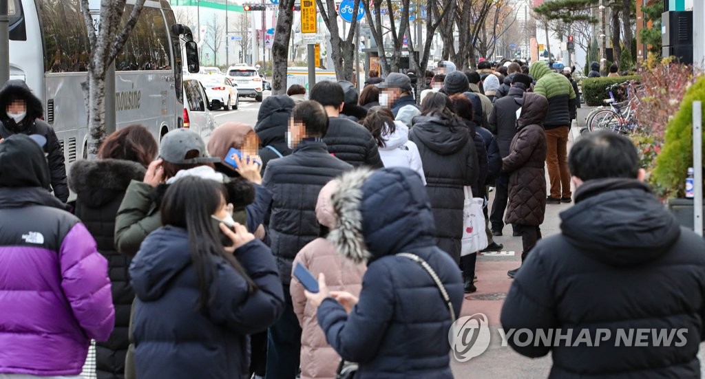 A sidewalk near a makeshift COVID-19 testing center in Seoul's southeastern district of Songpa is packed with citizens waiting in a line to be tested for the virus on Dec. 4, 2021, as South Korea's new daily coronavirus cases and deaths hit record high levels of 5,352 and 70, respectively. (Yonhap)