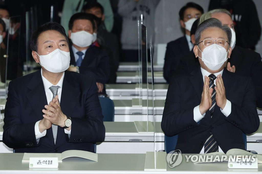 This pool photo, taken Dec. 9, 2021, shows Lee Jae-myung, presidential candidate of the ruling Democratic Party (R) and Yoon Suk-yeol, presidential candidate of the main opposition People Power Party. (Yonhap)