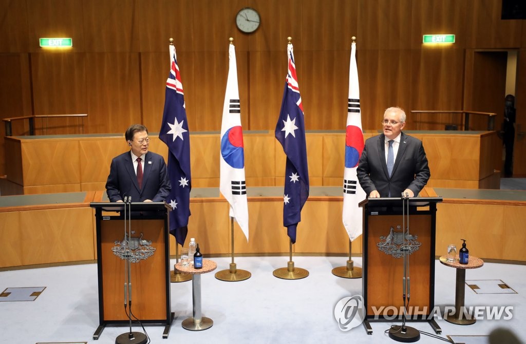 South Korean President Moon Jae-in (L) and Australia's Prime Minister Scott Morrison hold a joint press conference after their summit talks at the Parliament House in Canberra on Dec. 13, 2021. Moon arrived in Australia the previous day for a four-day state visit. (Yonhap)