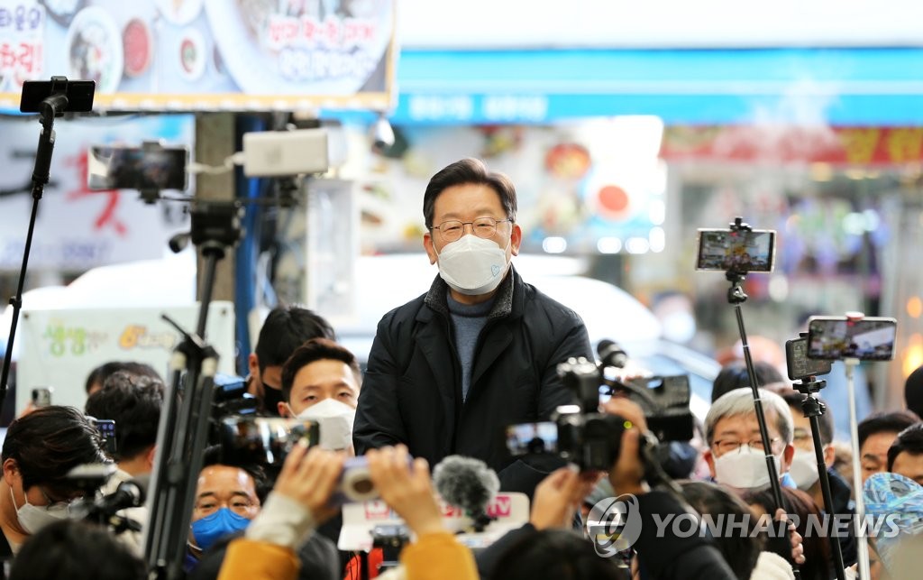 Ruling Democratic Party presidential nominee Lee Jae-myung meets with locals at a traditional market in the southeastern city of Pohang on Dec. 13, 2021. (Yonhap)