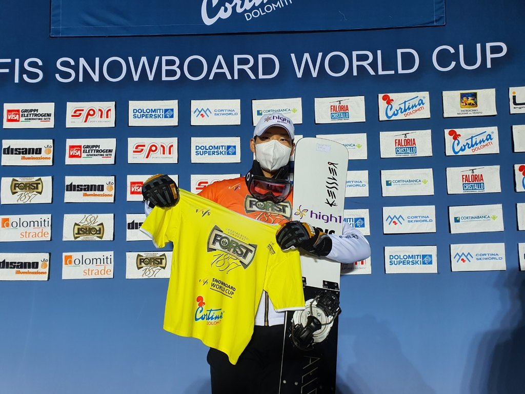 South Korean alpine snowboarder Lee Sang-ho holds up a yellow jersey showing his No. 1 overall ranking in the men's parallel giant slalom after winning silver in the discipline at the International Ski Federation Snowboard World Cup in Cortina d'Ampezzo, Italy, on Dec. 18, 2021, in the photo provided by the Korea Ski Association. (PHOTO NOT FOR SALE) (Yonhap)