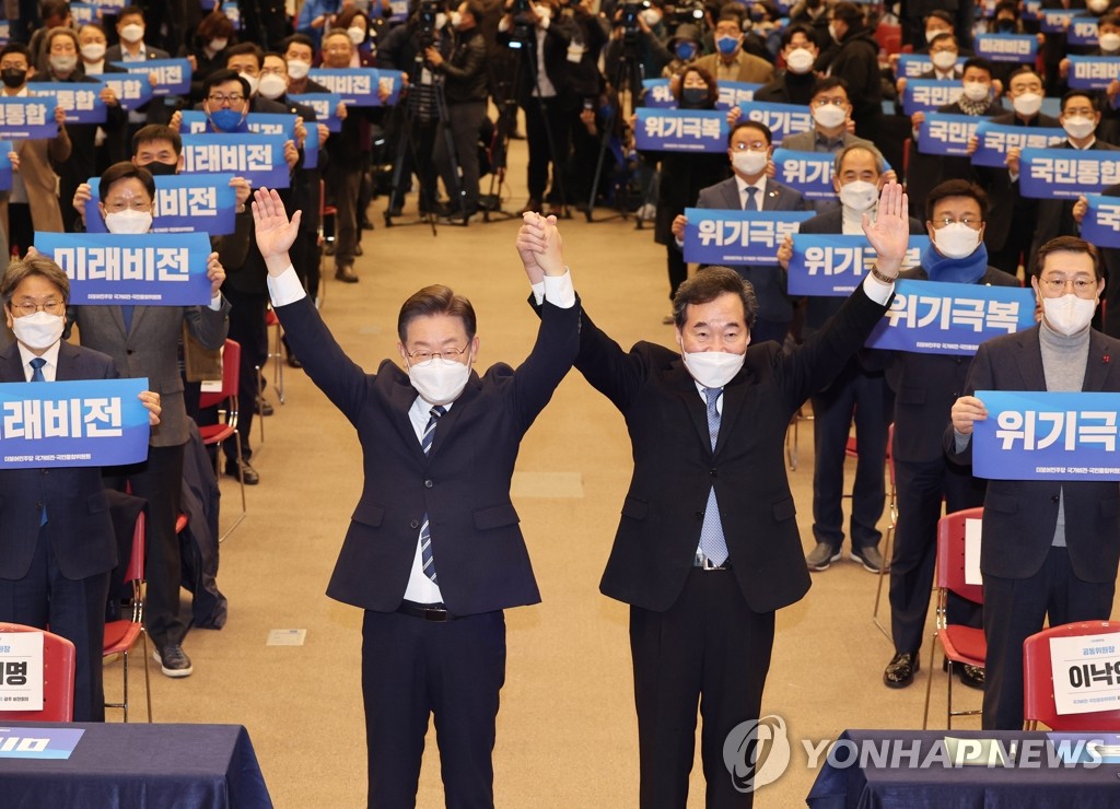 Lee Jae-myung (L), the presidential candidate of the ruling Democratic Party, poses with the party's former chief and the runner-up in its primary, Lee Nak-yon, during a meeting of its national vision and integration committee in the southwestern city of Gwangju on Jan. 5, 2022. (Yonhap)