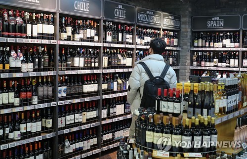 A shopper looks at a selection of wine at a large discount supermarket in Seoul on Jan. 5, 2022. (Yonhap) 
