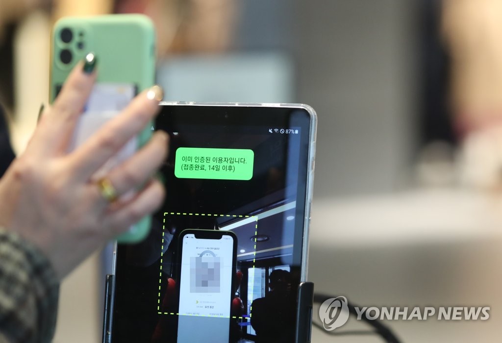 Une personne montre le code QR de vaccination à l'aide de son smartphone dans un grand magasin à Daegu le lundi 10 janvier 2022. 