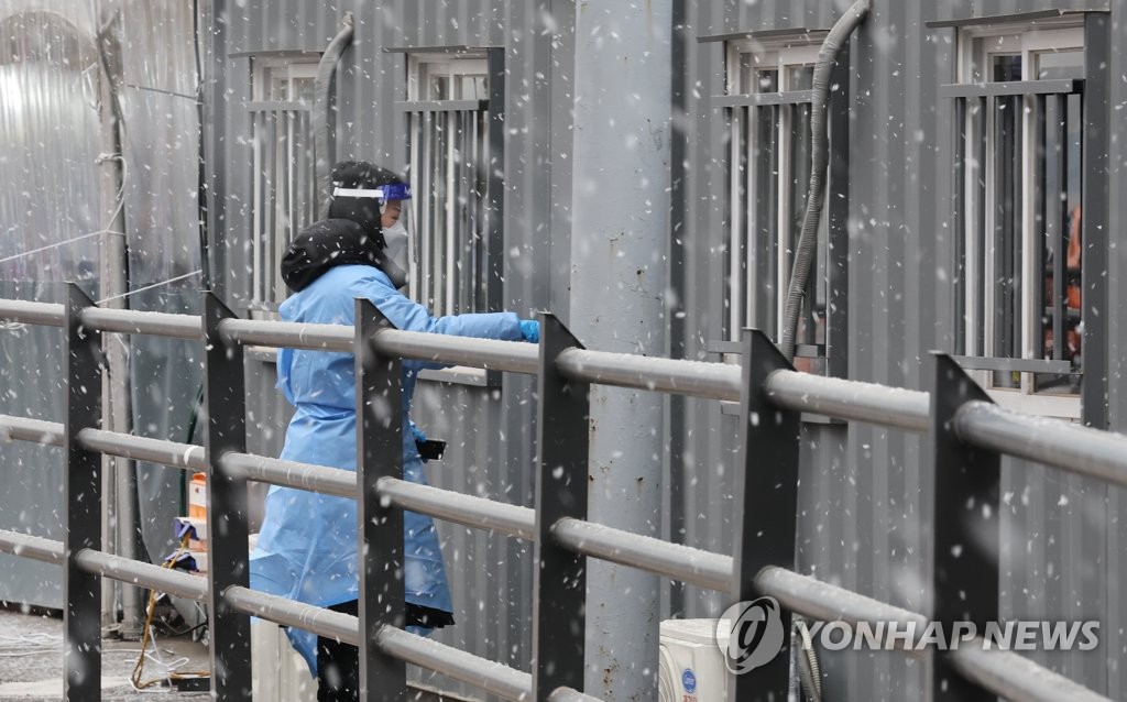 This photo taken Jan. 20, 2022 shows a medical worker entering a container booth set up for coronavirus tests in front of Seoul Station in central Seoul. (Yonhap)