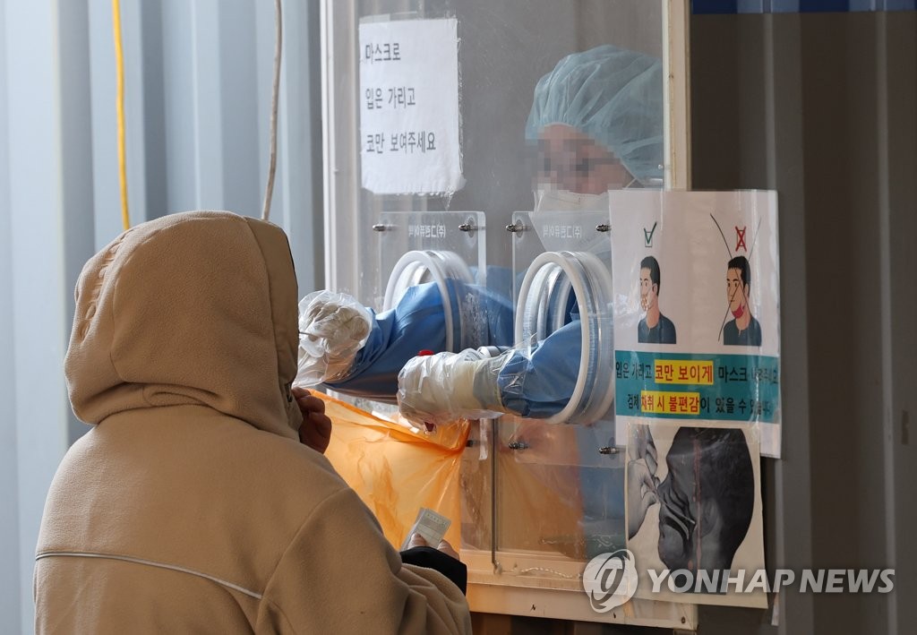 A person receives a COVID-19 test at a makeshift clinic near Seoul Station in Seoul on Jan. 23, 2022, as South Korea's daily coronavirus cases spiked to the second-largest figure since the pandemic outbreak amid the fast spread of the omicron variant. (Yonhap)