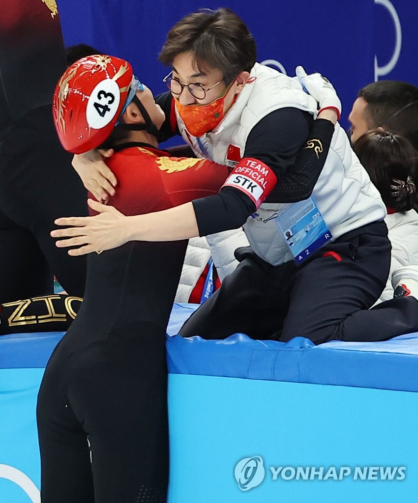 Kim Sun-tae (R), the South Korean-born head coach of the Chinese national short track speed skating team, embraces Fan Kexin after China won gold in the mixed team relay at the Beijing Winter Olympics at Capital Indoor Stadium in Beijing on Feb. 5, 2022. (Yonhap)