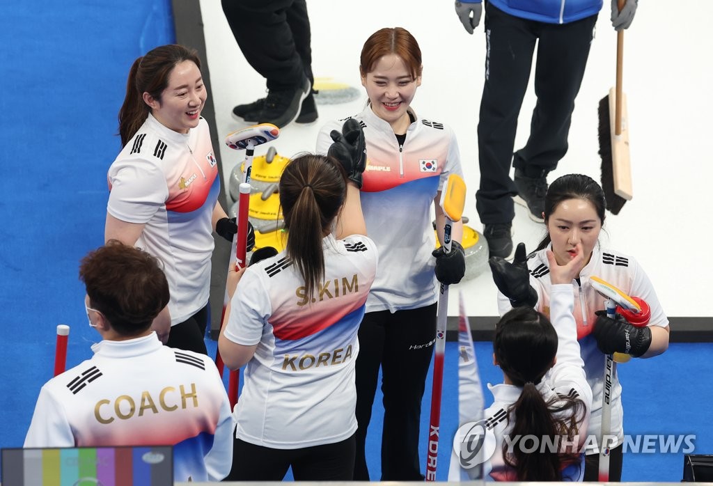 Members of the South Korean women's curling team at Beijing 2022 high-five each other after practice at the National Aquatics Centre in Beijing on Feb. 9, 2022. (Yonhap)