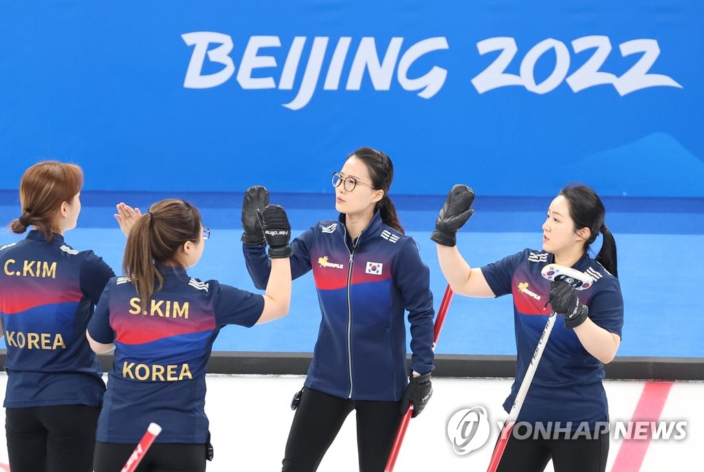 South Korean curlers Kim Cho-hi, Kim Seon-yeong, Kim Eun-jung and Kim Kyeong-ae (L to R) celebrate a point against Britain during their women's curling round robin game at the Beijing Winter Olympics at the National Aquatics Centre in Beijing on Feb. 11, 2022. (Yonhap)