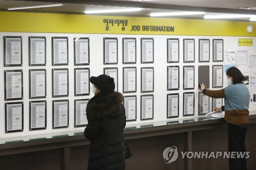 Una demandante de empleo observa un tablón de anuncios con información laboral, el 16 de febrero de 2022, en una oficina estatal de empleo, en Seúl. 