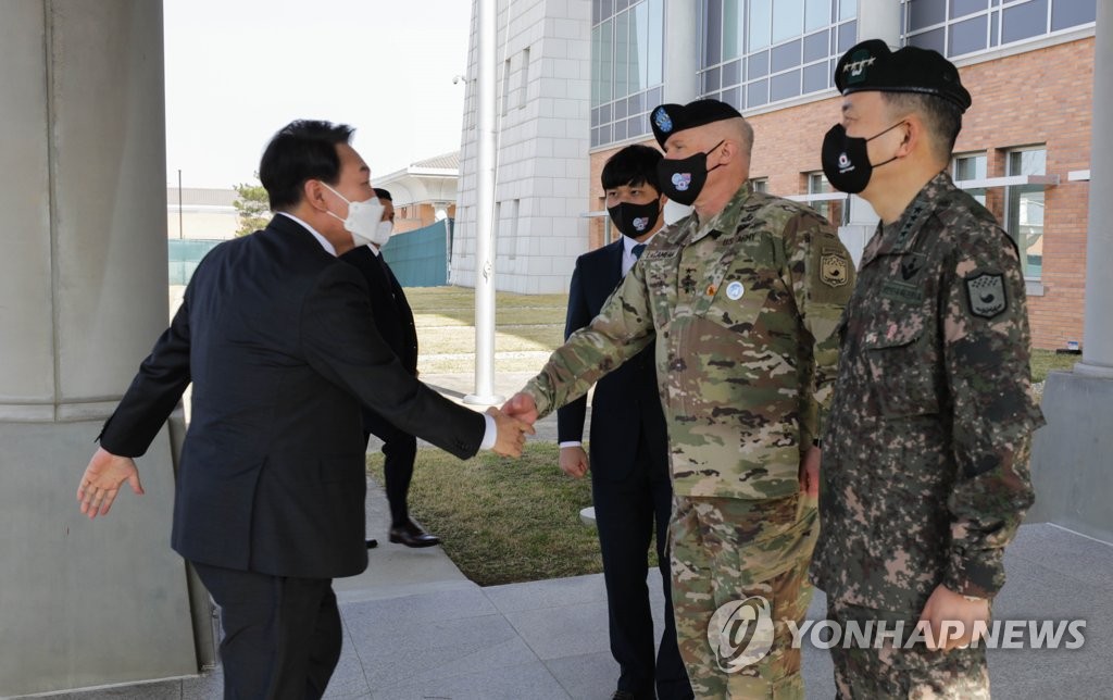 ラカメラ氏と握手する尹氏（左、在韓米軍提供）＝（聯合ニュース）≪転載・転用禁止≫