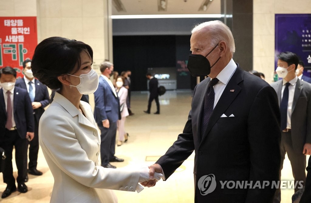 This photo, provided by the presidential office, shows first lady Kim Keon-hee (L) and U.S. President Joe Biden shaking hands ahead of a state dinner at the National Museum of Korea in Seoul on May 21, 2022. (PHOTO NOT FOR SALE) (Yonhap)