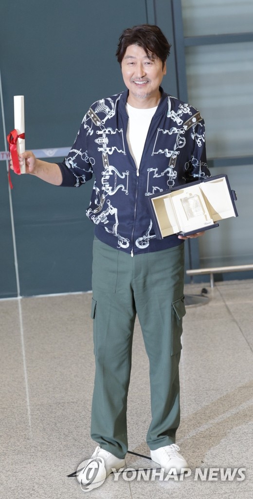 L'acteur Song Kang-ho pose avec son trophée de meilleur acteur, qu'il a remporté au 75e Festival de Cannes pour sa performance dans le film «Broker», à son arrivée à l'aéroport international d'Incheon, à l'ouest de Séoul, le 30 mai 2022. (Yonhap)