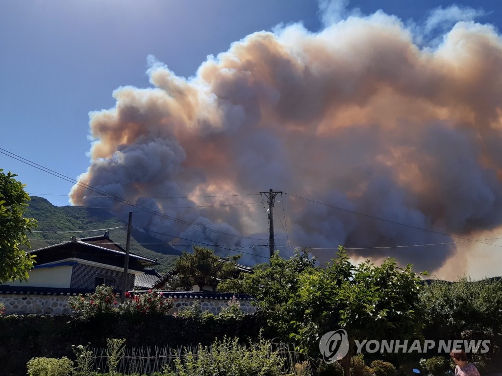 This image contributed by a news reader shows a fire spreading near a village in Miryang, around 280 km southeast of Seoul, on May 31, 2022. (PHOTO NOT FOR SALE) (Yonhap)