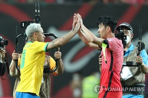 ６月にソウルで行われた韓国とブラジルの親善試合であいさつする孫興ミンとネイマール＝（聯合ニュース）