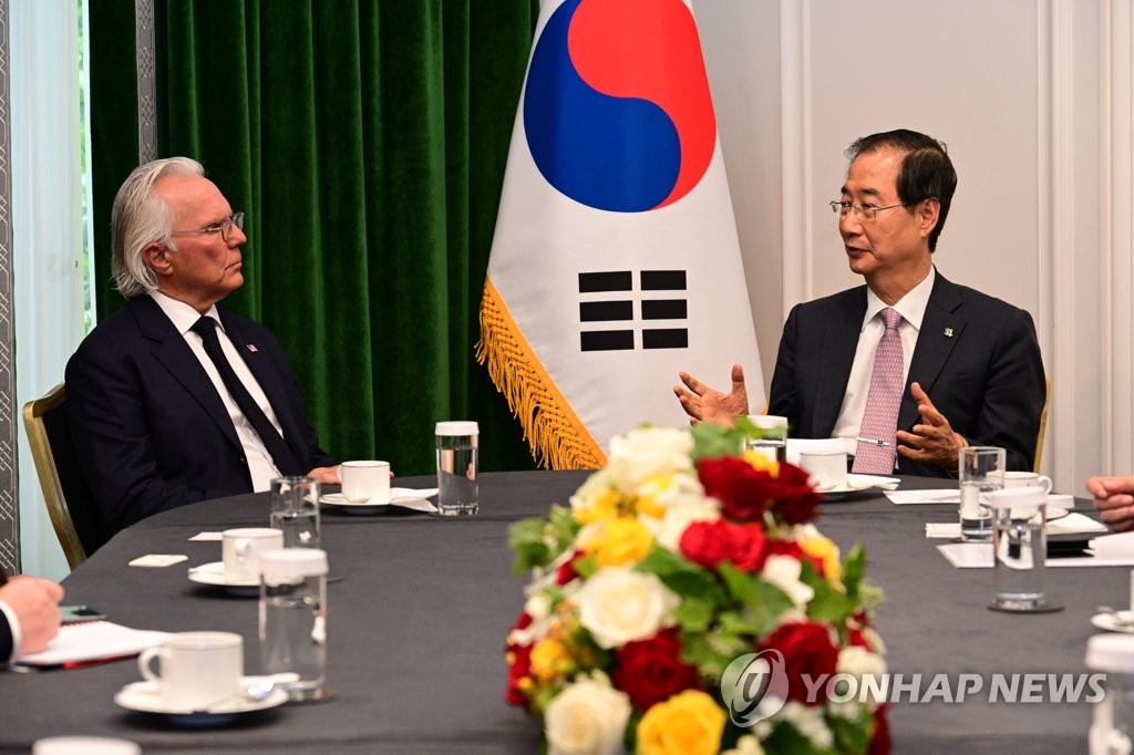 Prime Minister Han Duck-soo (R) meets with Robert Clark, co-chair of Minnesota USA Expo 2027, in Paris on June 20, 2022, in this photo provided by Han's office. (PHOTO NOT FOR SALE) (Yonhap)