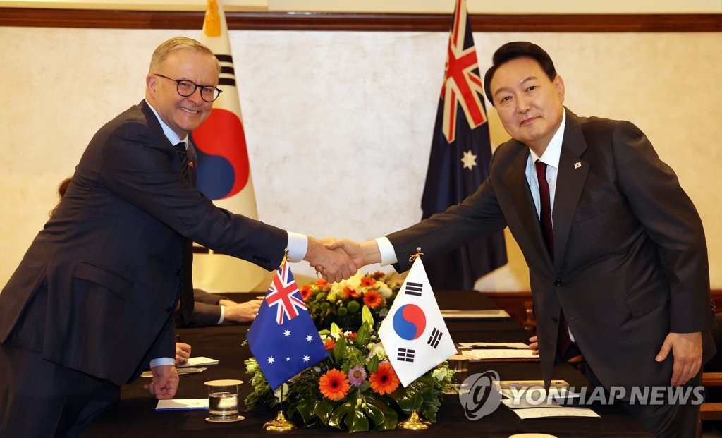 South Korean President Yoon Suk-yeol (R) poses for a photo with Australian Prime Minister Anthony Albanese as they meet on the sidelines of the North Atlantic Treaty Organization summit in Madrid on June 28, 2022. (Yonhap)
