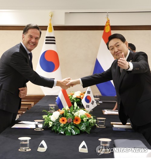 South Korean President Yoon Suk-yeol (R) poses for a photo with Dutch Prime Minister Mark Rutte as they meet on the sidelines of a meeting of the North Atlantic Treaty Organization in Madrid on June 29, 2022. (Yonhap)