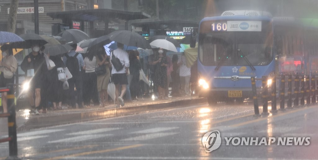 서울 시내 정류장에서 시민들이 비를 피하며 버스를 기다리고 있다. [연합뉴스 자료사진]