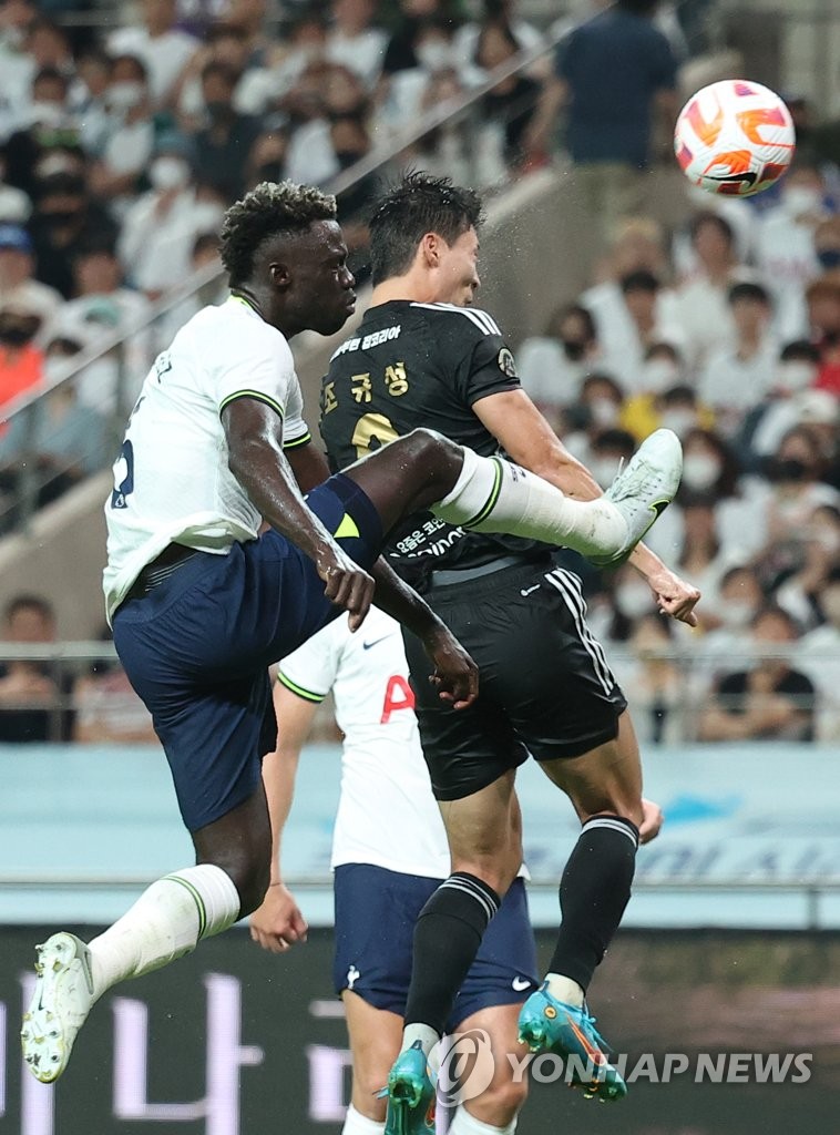 Cho Gue-sung of Team K League (R) heads in a goal ahead of Davinson Sanchez of Tottenham Hotspur during the teams' exhibition match at Seoul World Cup Stadium in Seoul on July 13, 2022. (Yonhap)