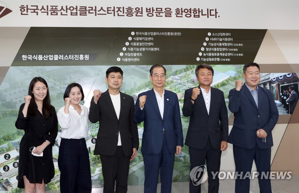 Prime Minister Han Duck-soo (4th from L) poses for a photo during a visit to the national food cluster in Iksan, 246 kilometers south of Seoul, on Aug. 3, 2022. (Yonhap)