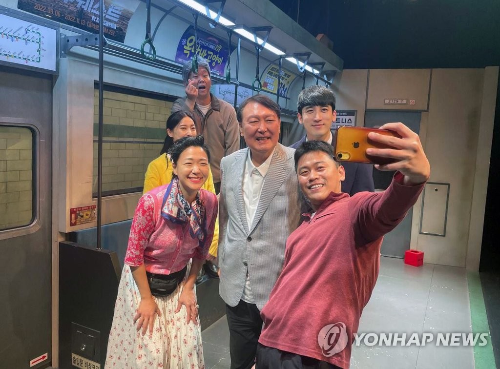 Les acteurs d'un théâtre situé à Daehak-ro à Séoul prennent une selfie avec le président Yoon Suk-yeol. Yoon a profité de voir le théâtre durant ces vacances d'une semaine, le mercredi 3 août 2022, avec son épouse, Kim Keon-hee. (Photo fournie par le bureau présidentiel. Revente et archivage interdits) 