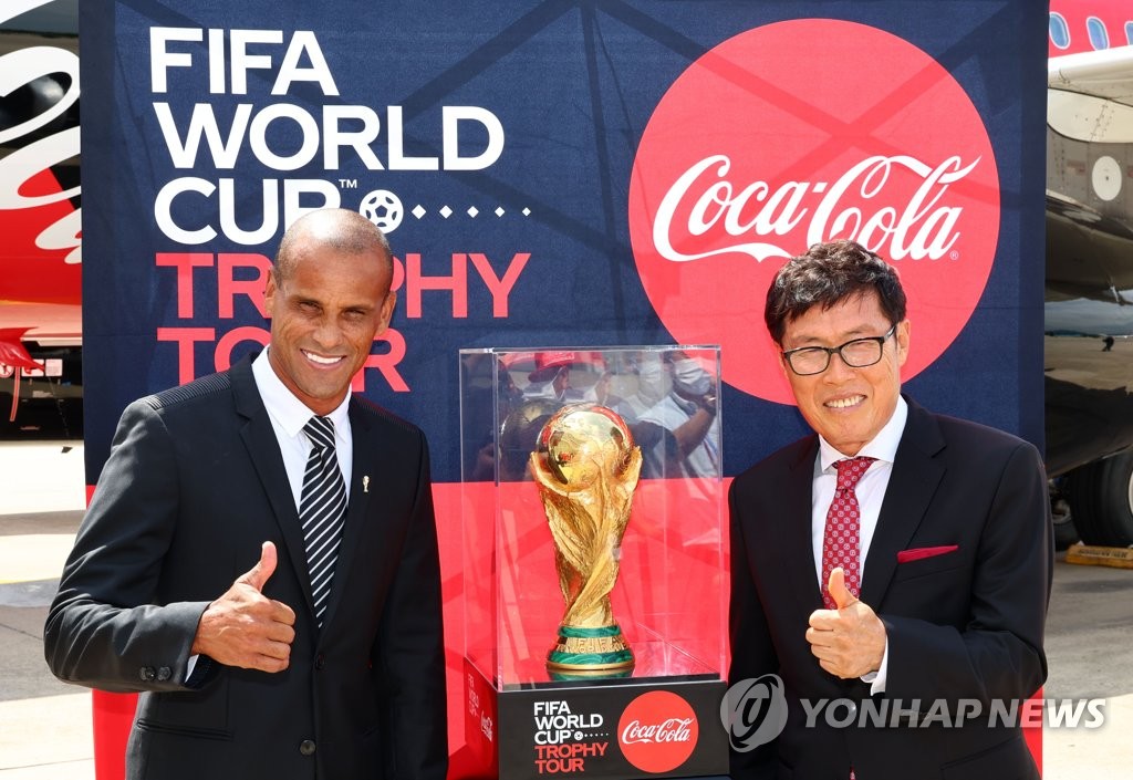 Former Brazil star and FIFA global ambassador Rivaldo (L) and former South Korean international Cha Bum-kun pose with the FIFA World Cup Trophy, which landed at Gimpo International Airport in Seoul on Aug. 24, 2022, as part of its global tour. (Pool photo) (Yonhap)