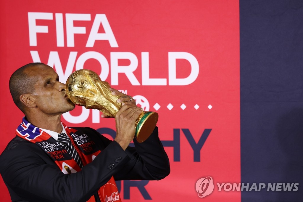 Rivaldo, former Brazil international and FIFA global ambassador, kisses the FIFA World Cup Trophy during a media showcase in Seoul on Aug. 24, 2022. (Yonhap)
