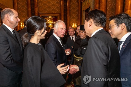 South Korean President Yoon Suk-yeol (2nd from R) shakes hands with King Charles III as he joins a reception at Buckingham Palace in London on Sept. 18, 2022, to offer condolences over the death of Queen Elizabeth II, in this photo provided by the British Foreign Ministry. (PHOTO NOT FOR SALE) (Yonhap)