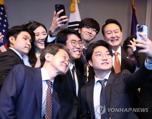 South Korean President Yoon Suk-yeol (R, rear) takes a selfie with a group of students after attending a digital vision forum at New York University in New York on Sept. 21, 2022. (Yonhap)
