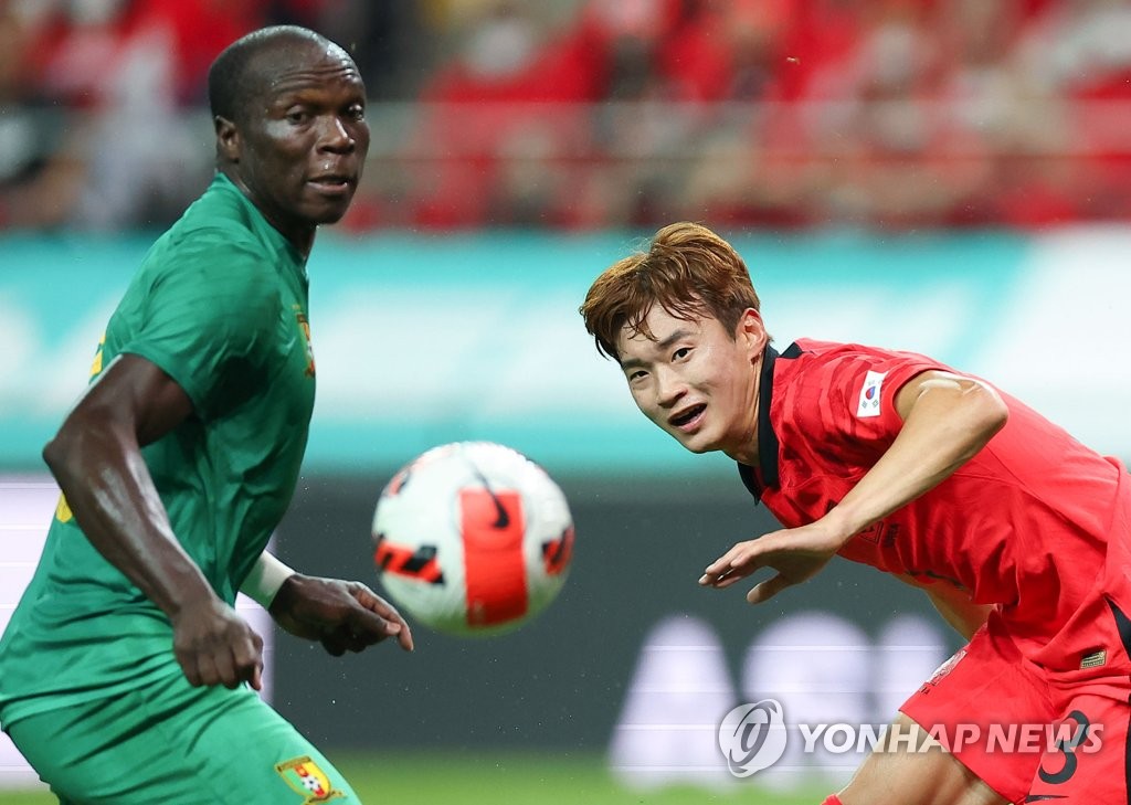 Kim Jin-su of South Korea (R) follows the flight of the ball against Cameroon during the teams' men's friendly football match at Seoul World Cup Stadium in Seoul on Sept. 27, 2022. (Yonhap)